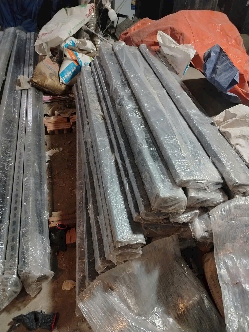 Thanh sắt dài bọc nilon xếp chồng trong kho chuẩn bị thi công xây dựng
